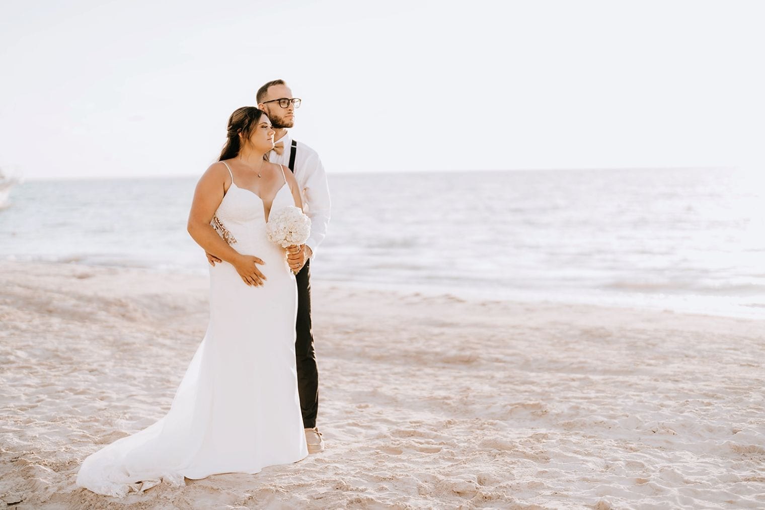 Bride-and-groom-posing-on-the-beach-with-scenic-Jamaica-sunset-in-the-background