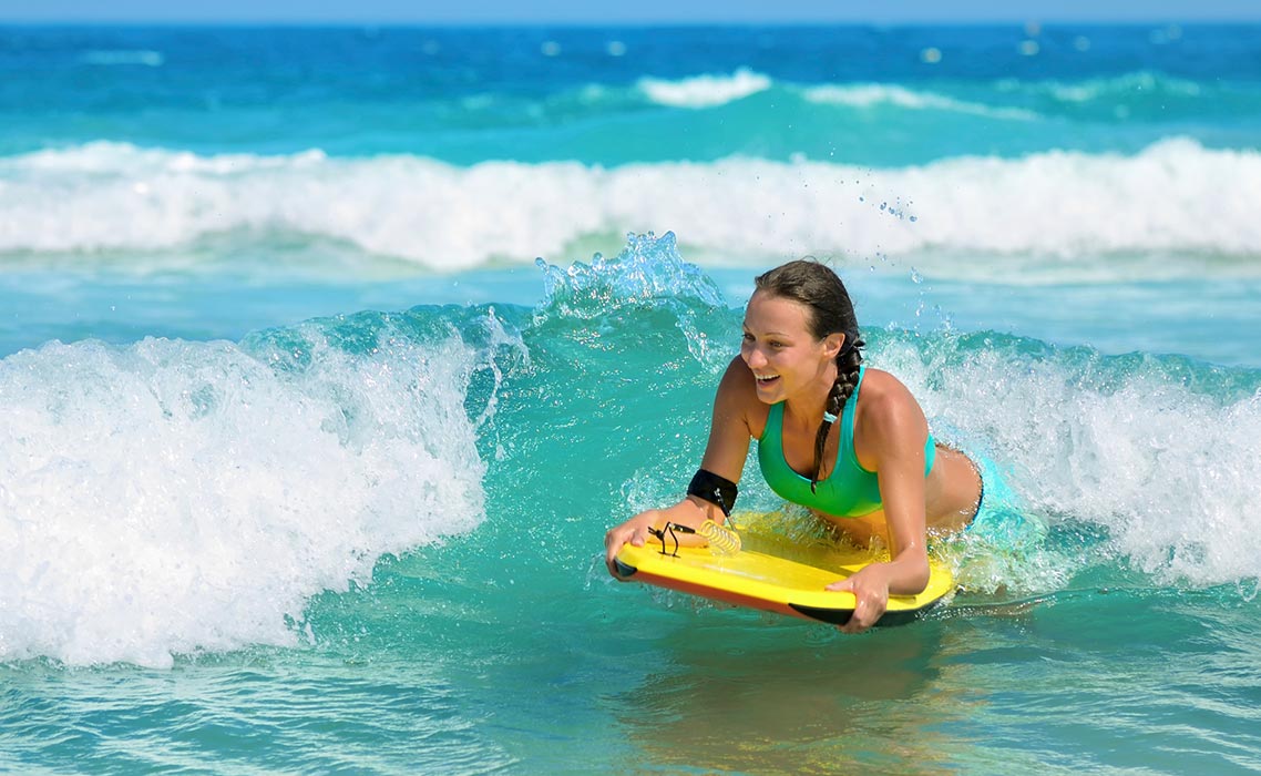 https://cdn.sandals.com/beaches/v12/images/activities/watersports//slider/woman-bodyboarding.jpg