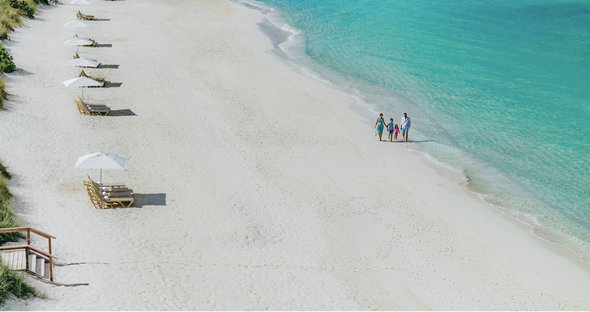 Official supplier image of a family walking the white sand beach at Beaches Turks and Caicos