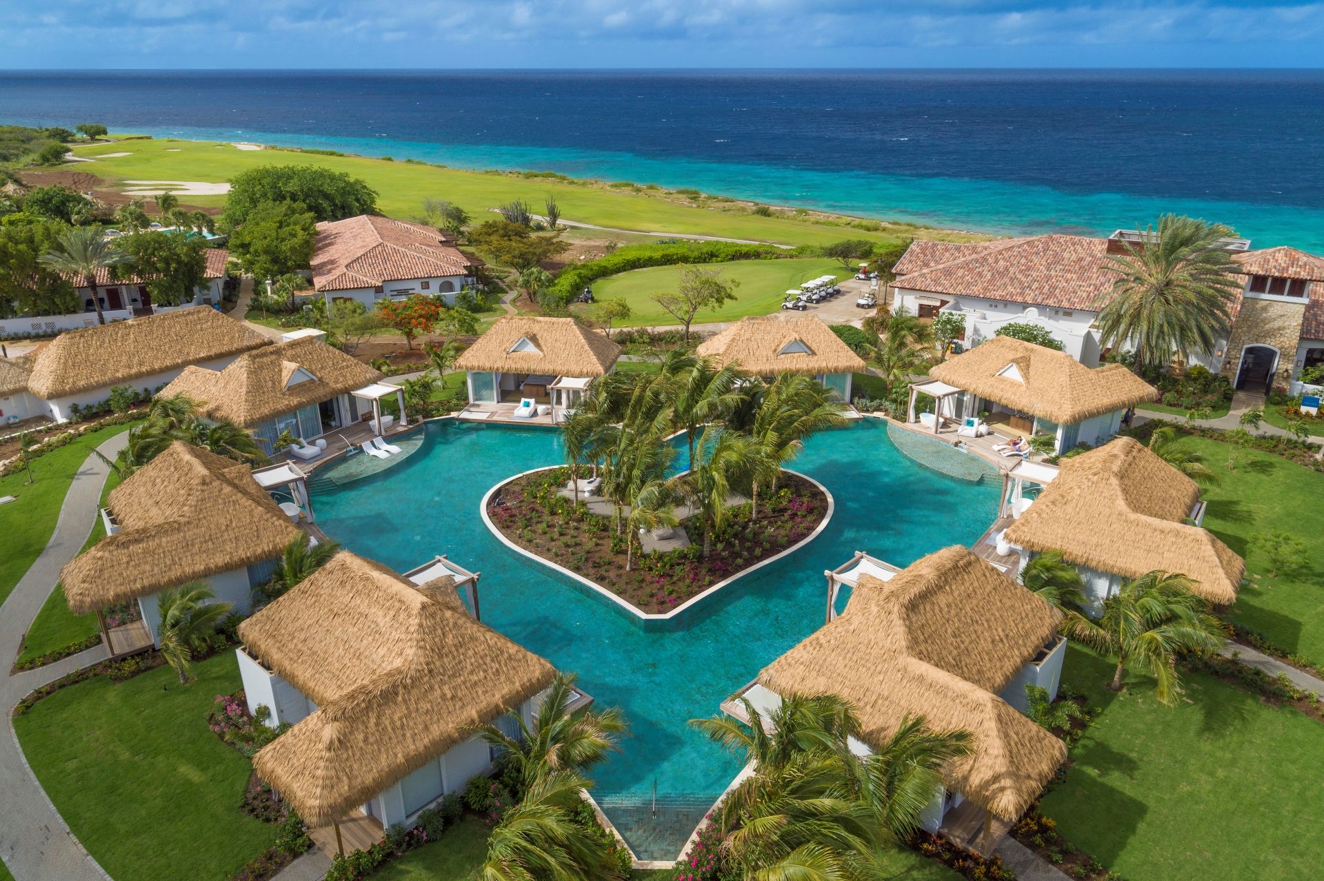 sandals curacao resort with heart shaped pool and ocean in the distance